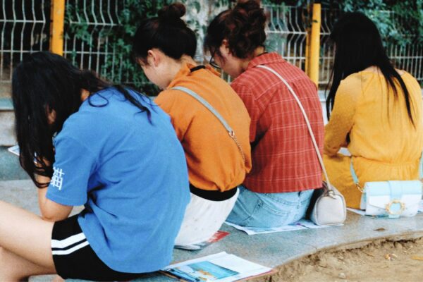woman wearing blue crew-neck shirt sitting on gray marble bench