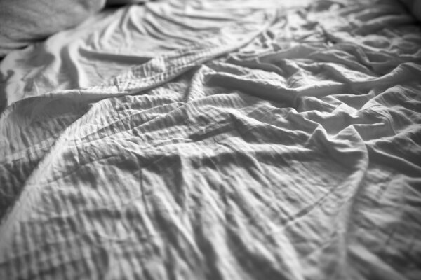 Wrinkled bed sheets look soft and inviting.
