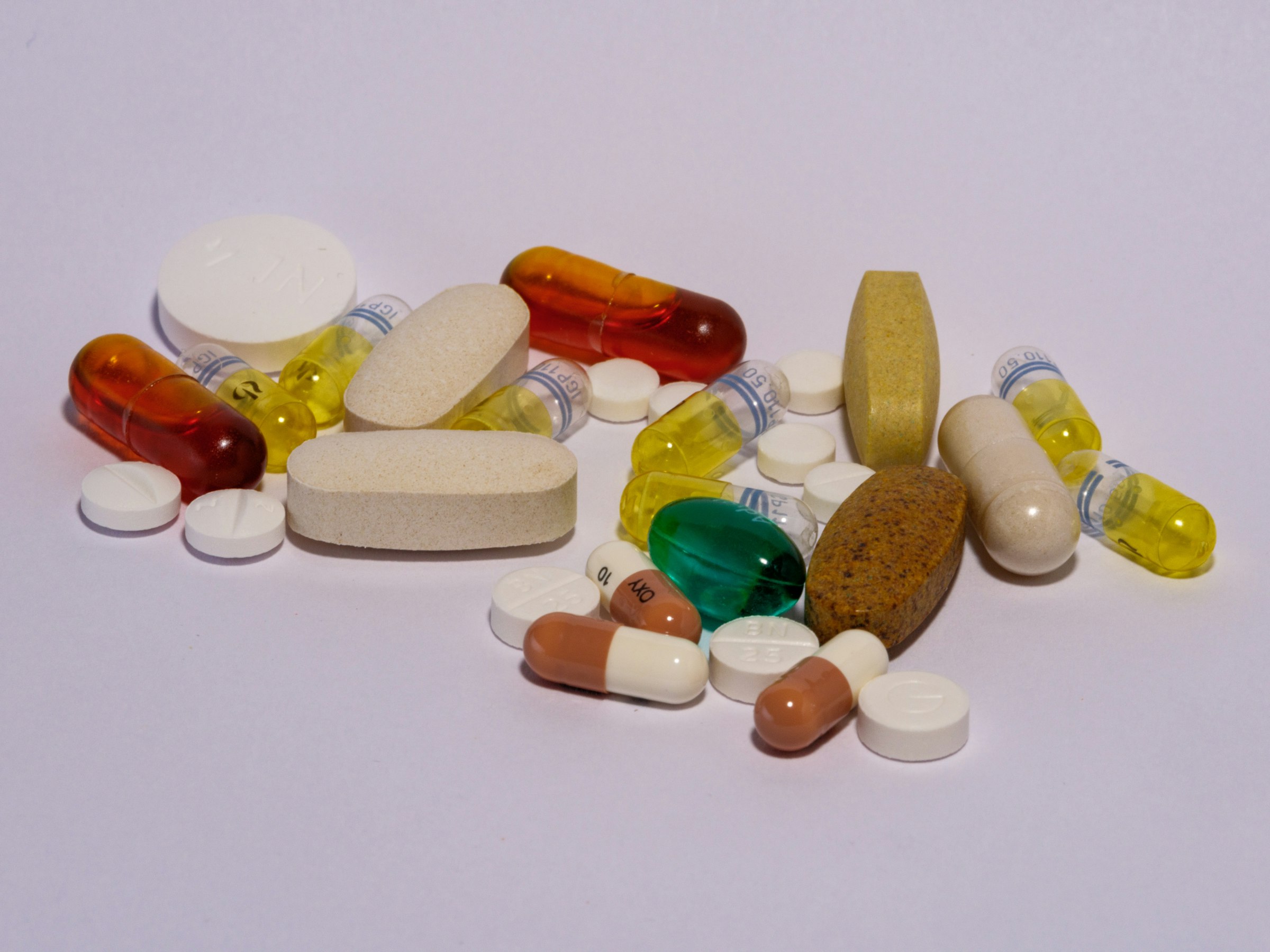 A pile of pills sitting on top of a white table