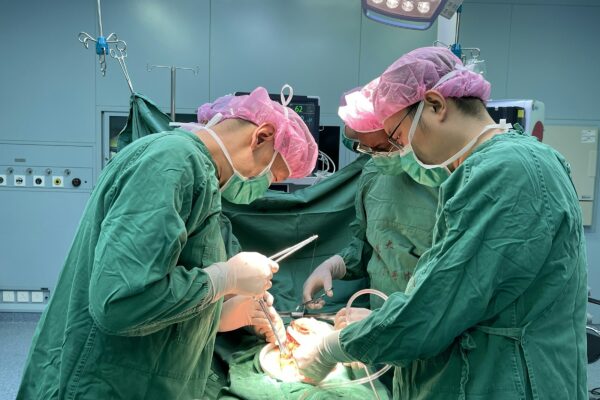 Surgeons performing a medical operation in a hospital operating room.