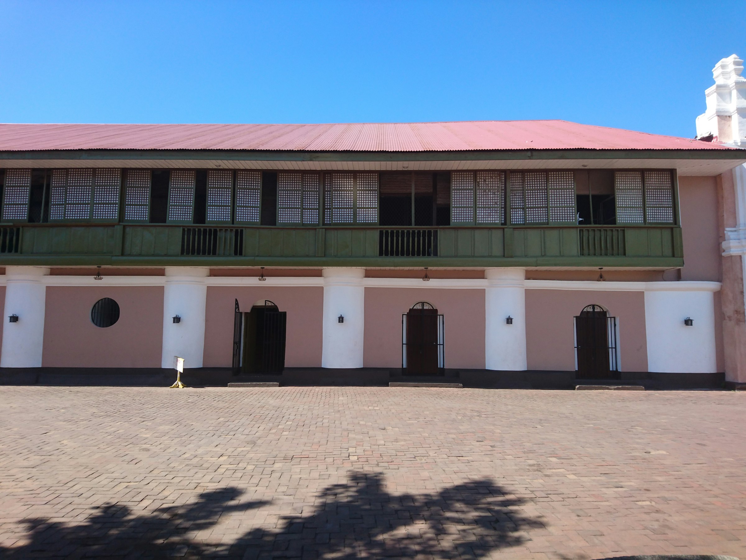 a pink and white building with a red roof