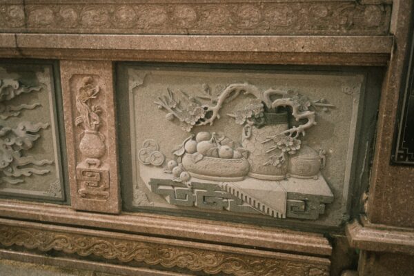 Stone relief depicts intricate asian carvings.