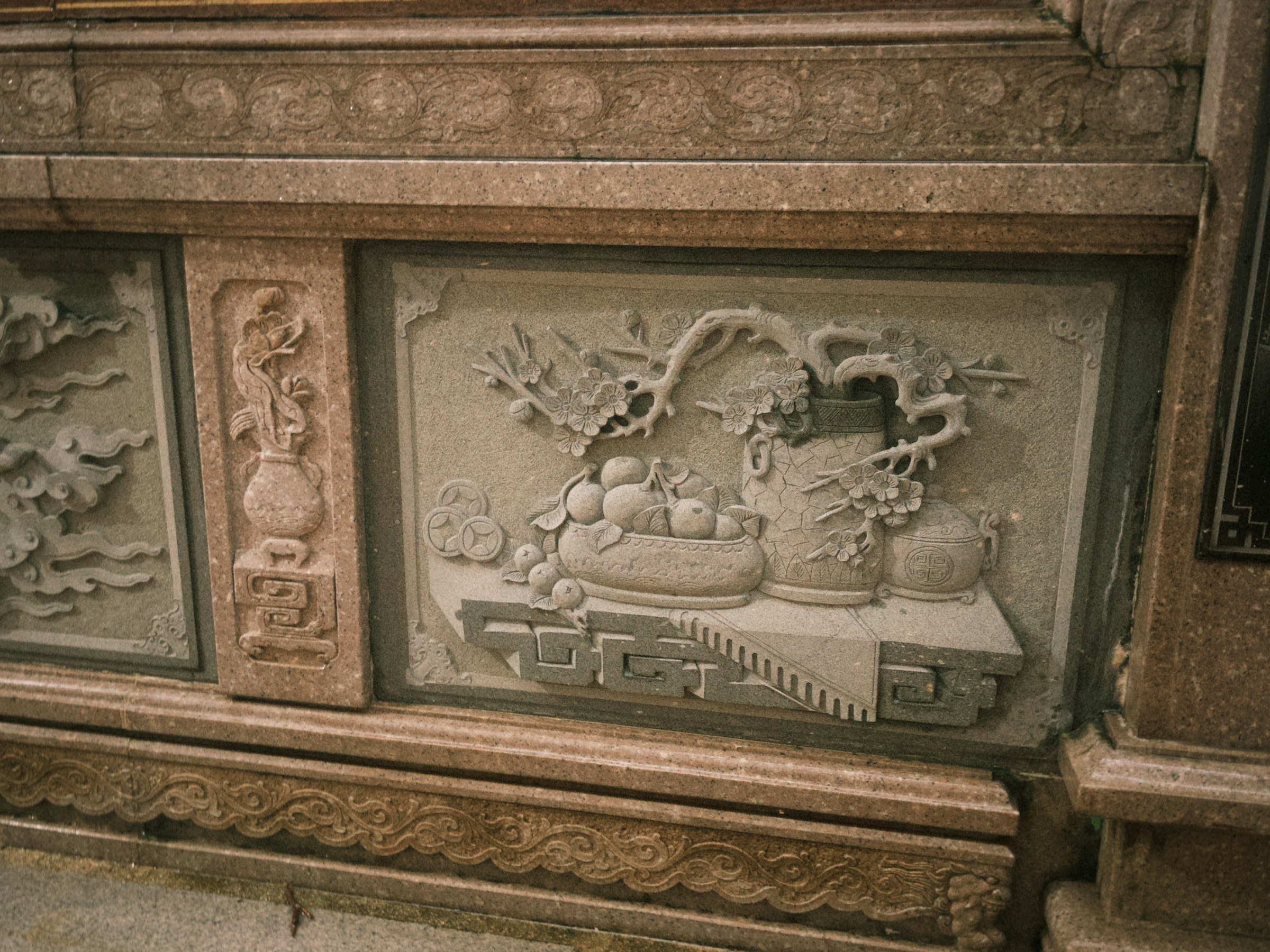 Stone relief depicts intricate asian carvings.