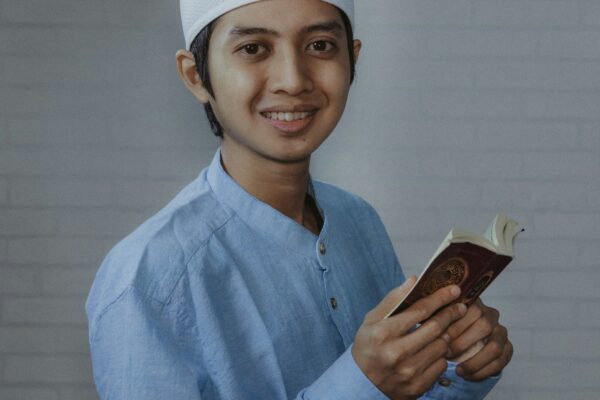 man in blue dress shirt holding brown smartphone