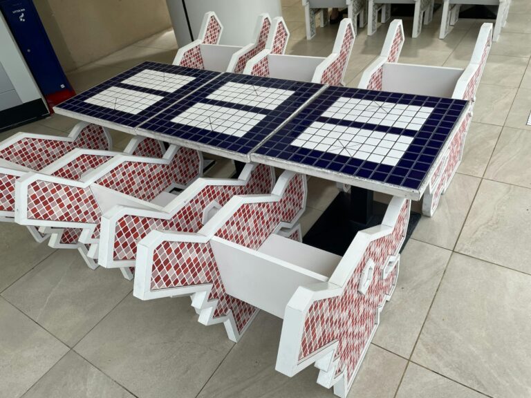 a table and chairs made out of red, white and blue tiles