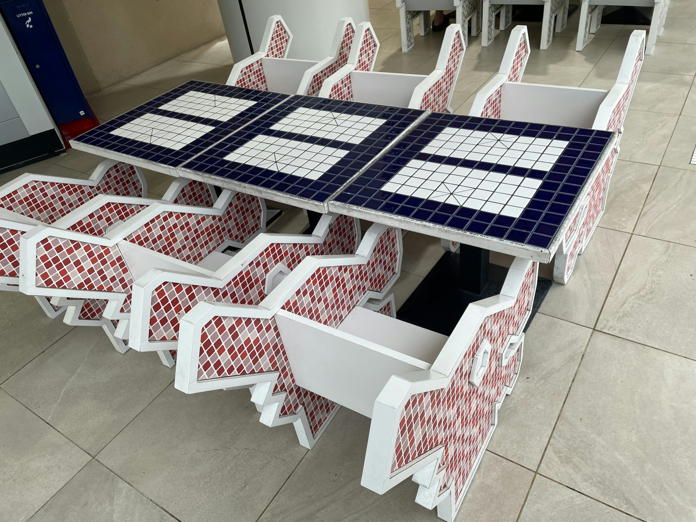 a table and chairs made out of red, white and blue tiles