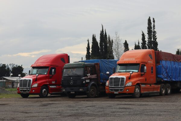Three trucks are parked in a lot.