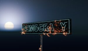 Street sign for democracy burning at night