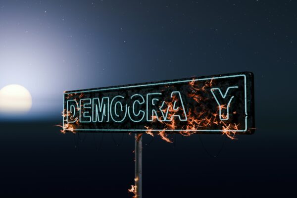 Street sign for democracy burning at night