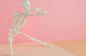 a skeleton is dancing on a pink background