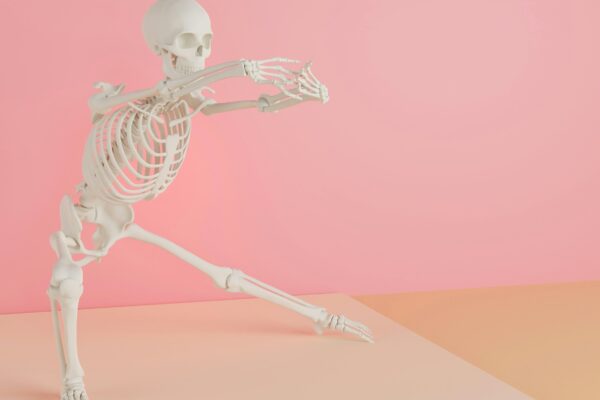 a skeleton is dancing on a pink background