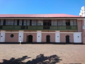 a pink and white building with a red roof