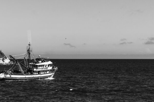 a black and white photo of a boat in the ocean