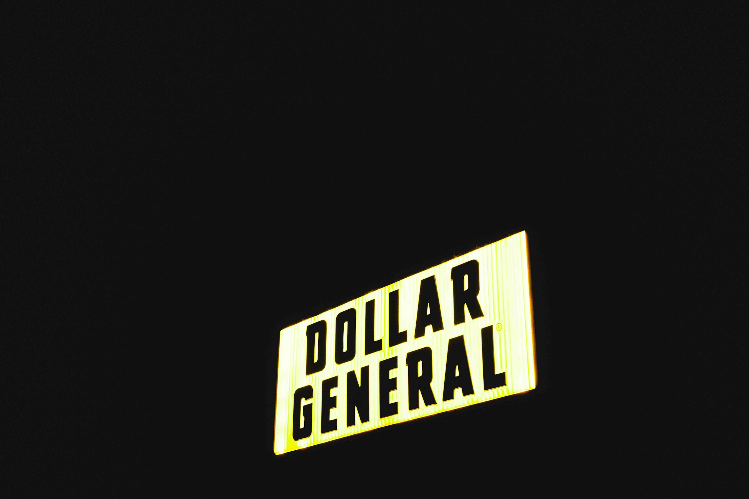 a street sign that reads dollar general at night
