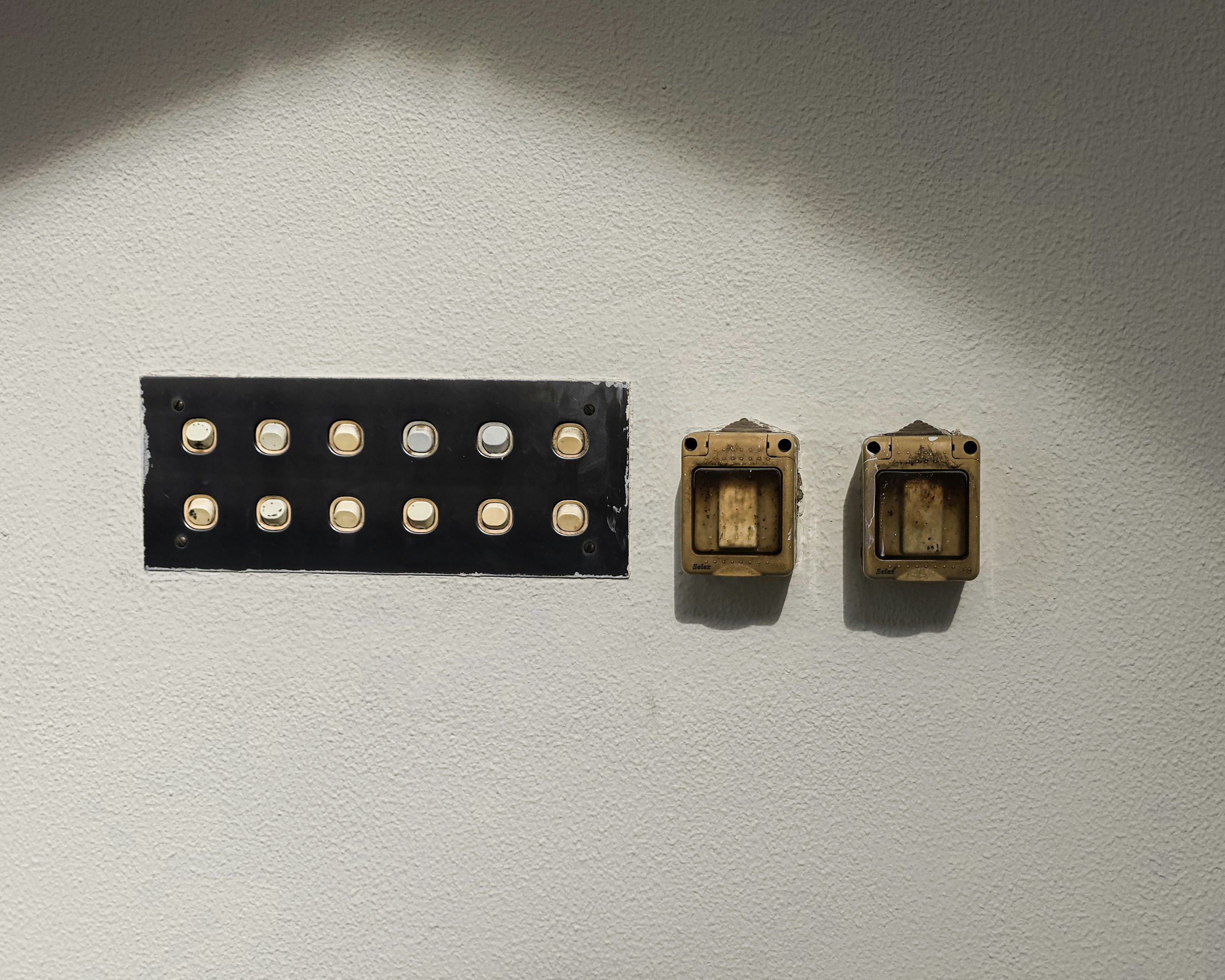 Vintage light switches are mounted on the wall.