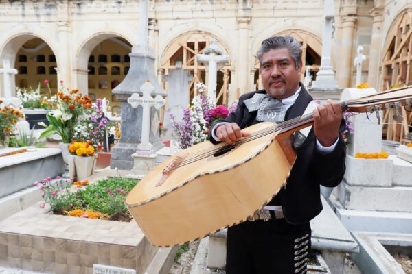 man in gray and black jacket holding brown acoustic guitar