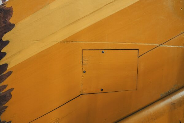 A close up of the side of a yellow airplane