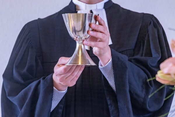 A man in a robe holding a wine glass