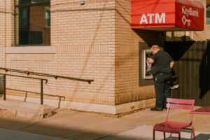 A man standing outside of a building next to a red chair