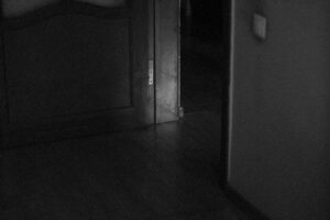 a black and white photo of a door in a dark room