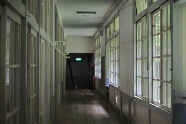 a long hallway with several windows and a green light