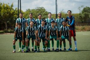A soccer team stands together on a field.