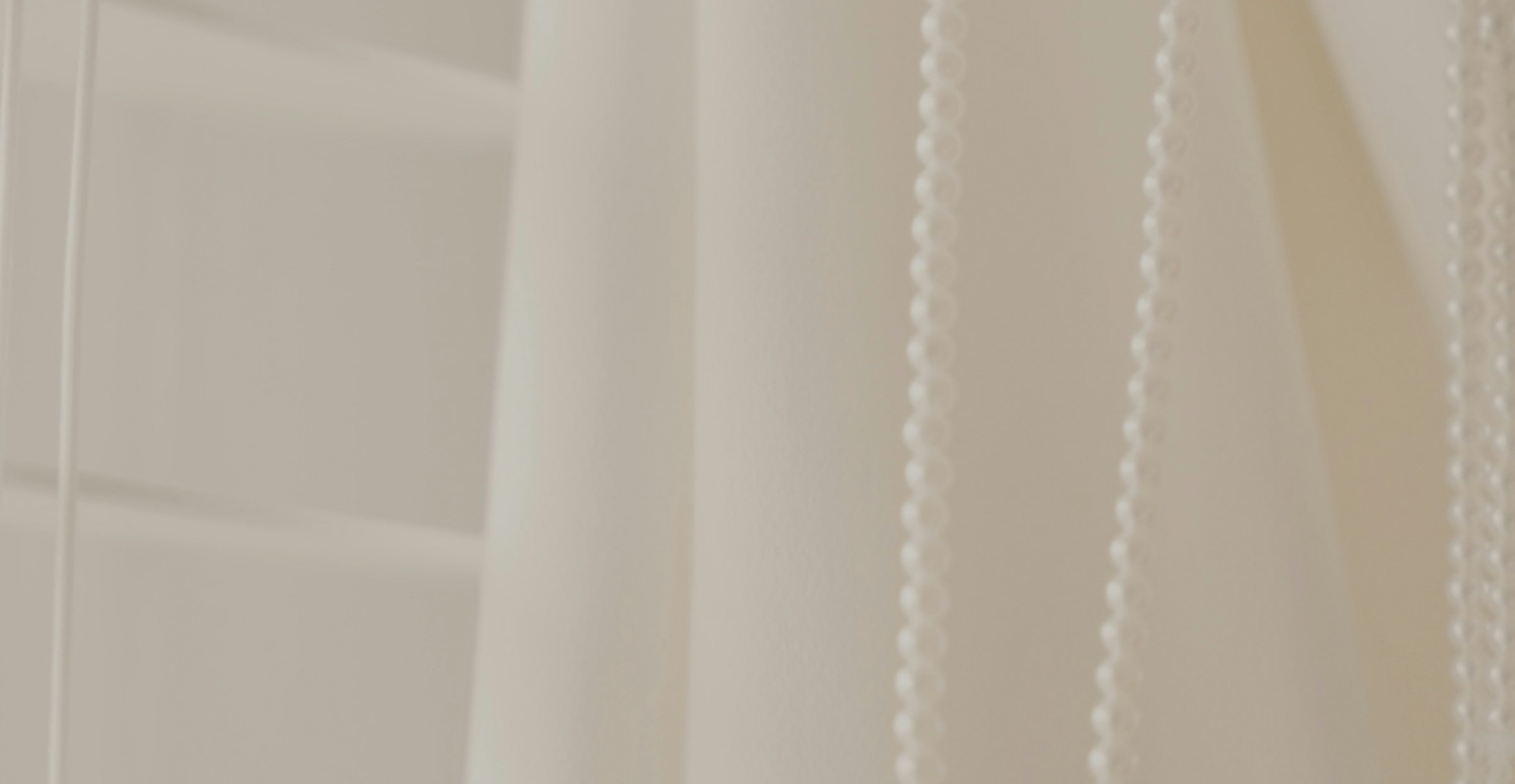 a close up of a white curtain with beads hanging from it