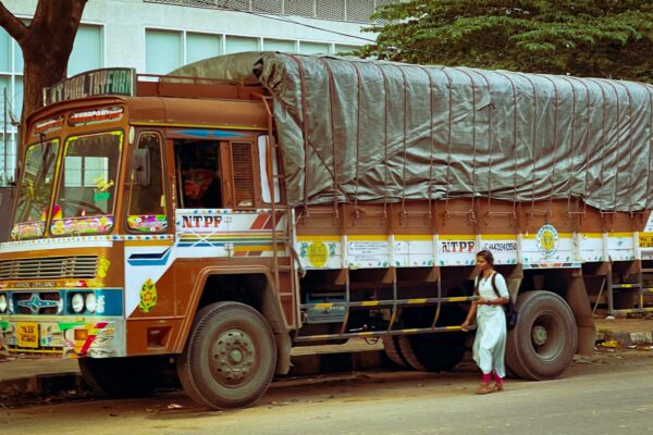 a man standing next to a truck with a tarp on it