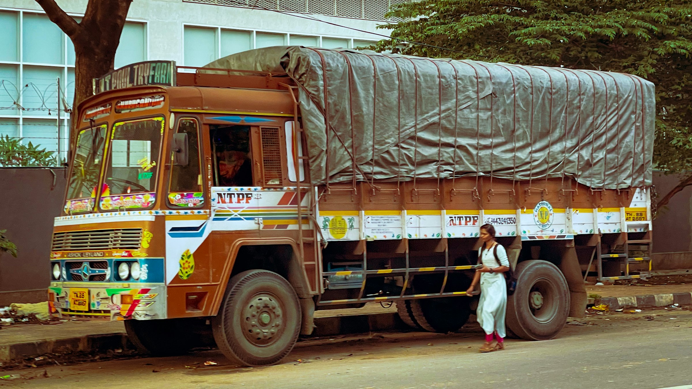 a man standing next to a truck with a tarp on it