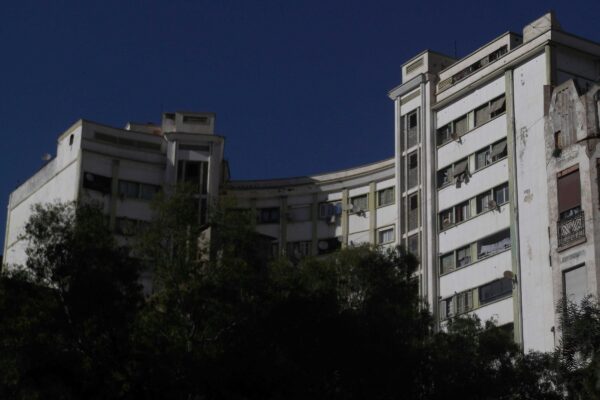 Modern white buildings against a clear blue sky.