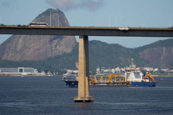a bridge over a body of water with a mountain in the background