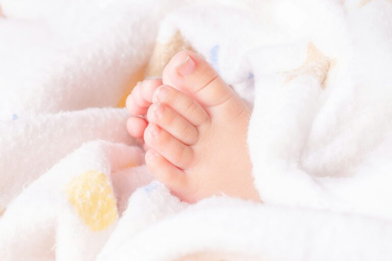 Close-up of tiny baby feet wrapped in soft blanket