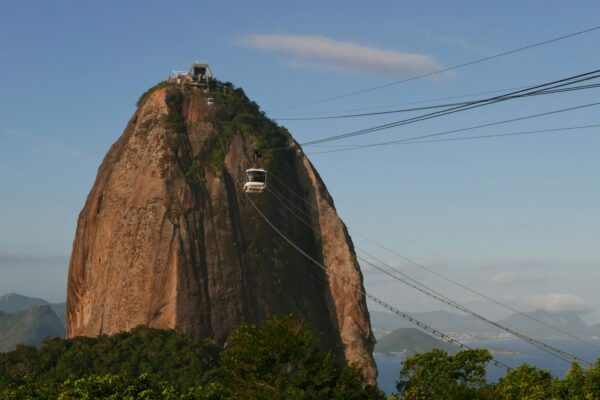 a car driving on a cliff with Sugarloaf Mountain in the background