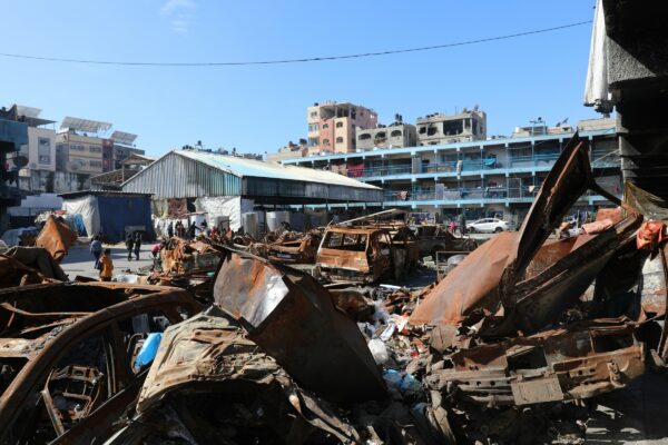 A man standing next to a pile of junk