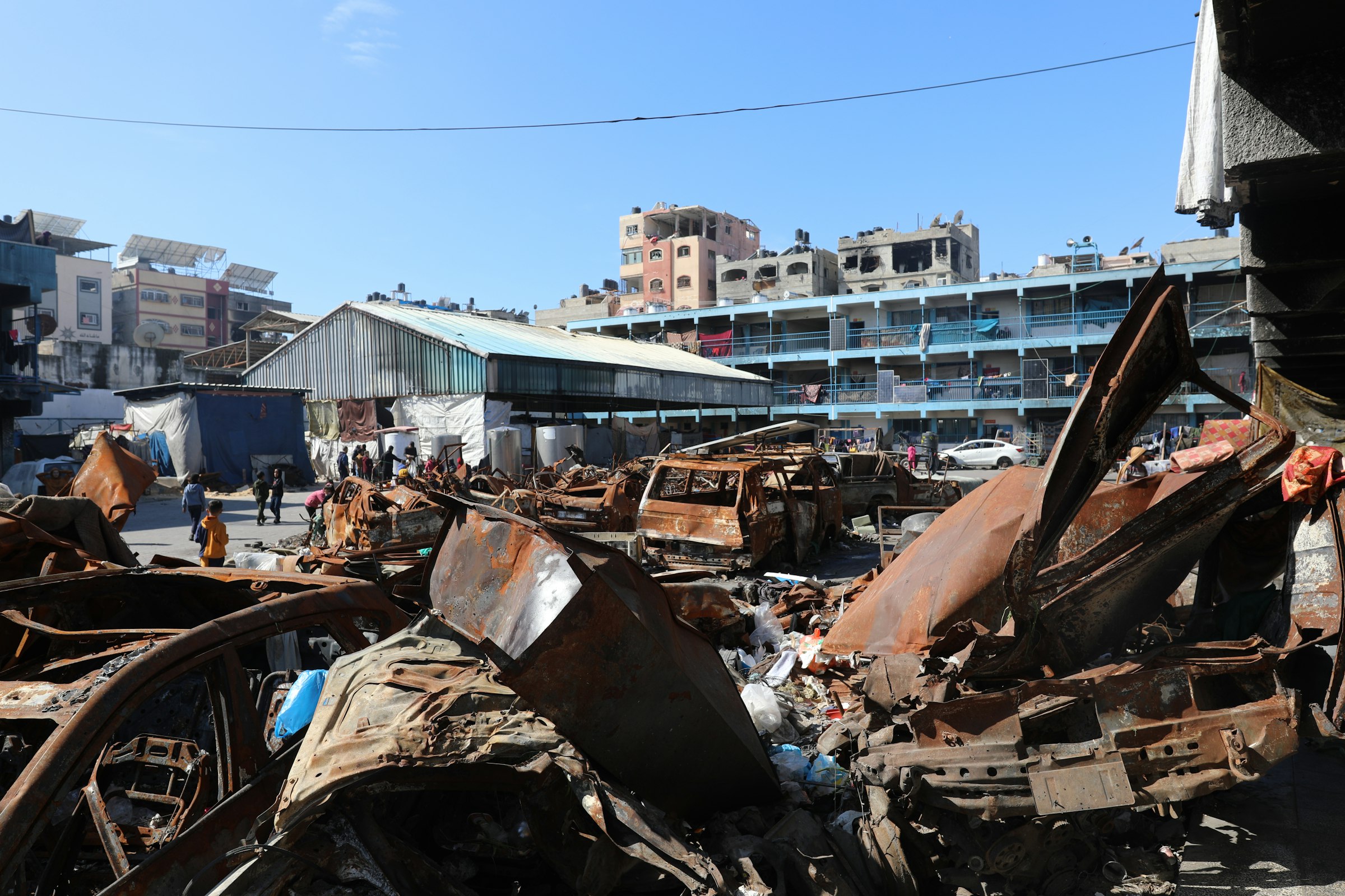 A man standing next to a pile of junk