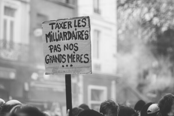 a protest sign in front of a crowd of people