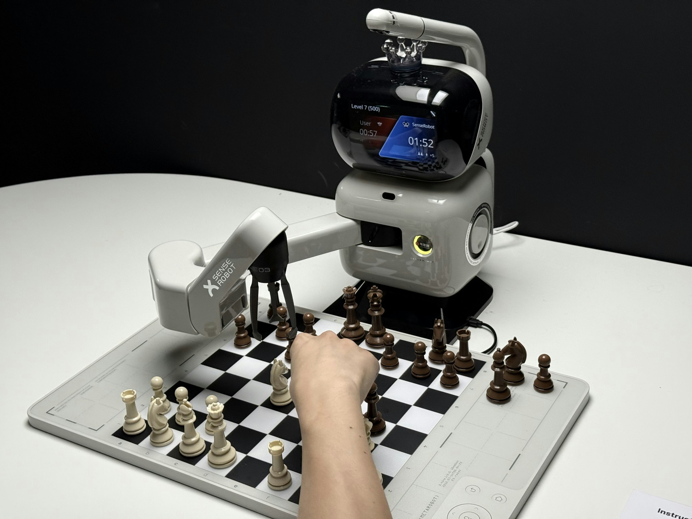 Robot arm playing chess with a human hand
