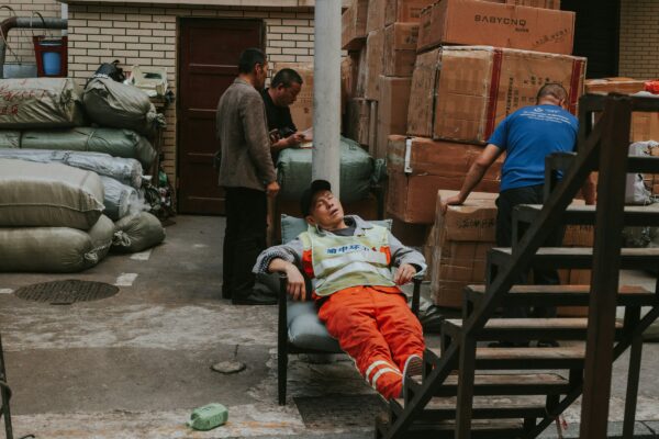 a man laying on a chair next to a pile of boxes