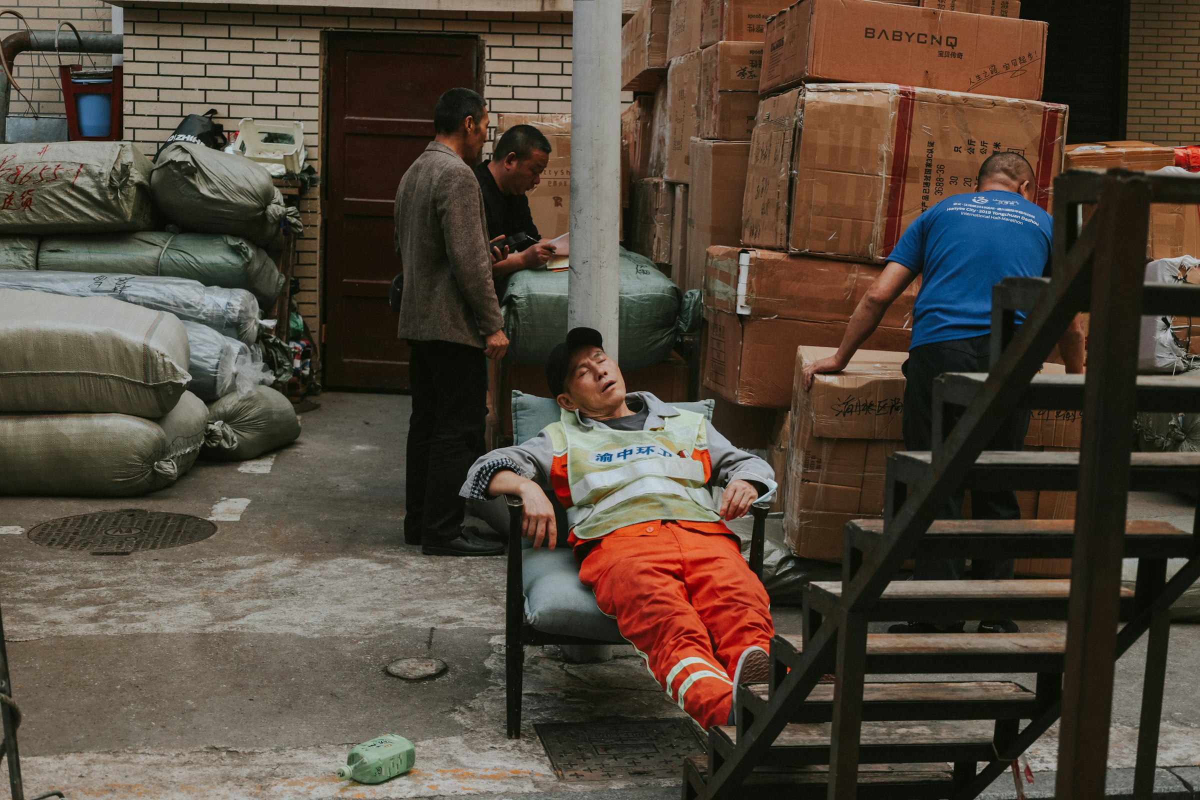 a man laying on a chair next to a pile of boxes