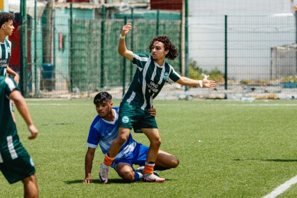 Soccer players are arguing after a foul.