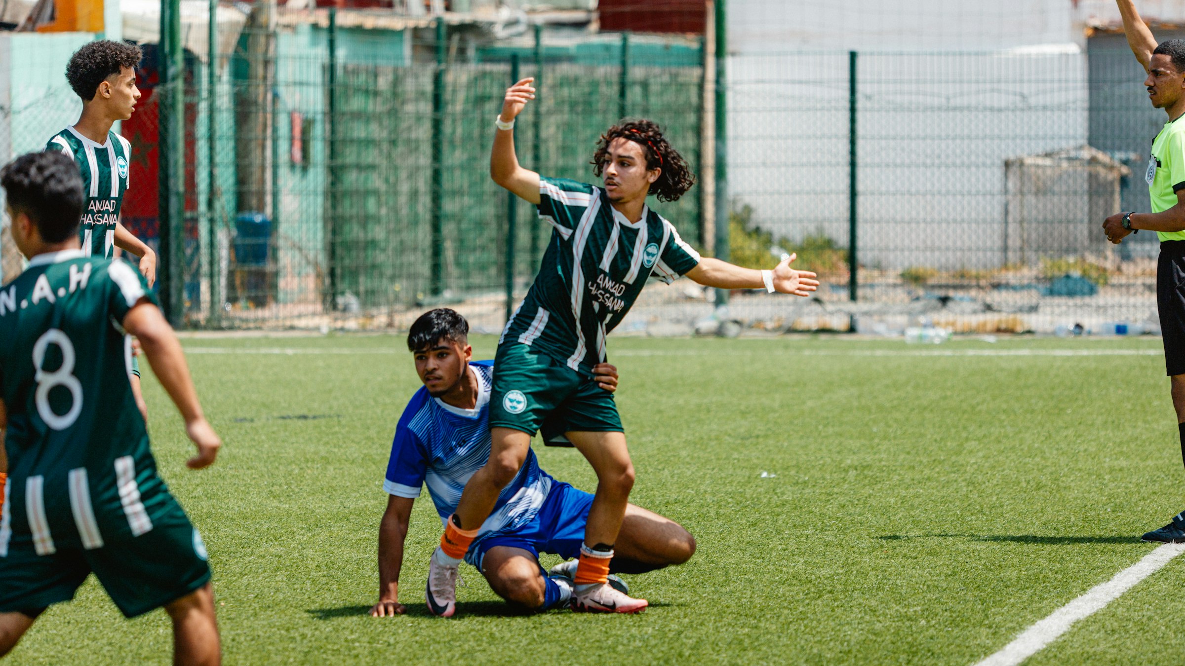 Soccer players are arguing after a foul.