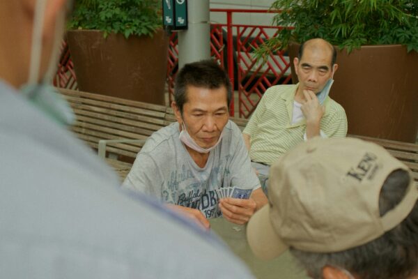 man in blue and white zip up jacket sitting beside woman in white long sleeve shirt