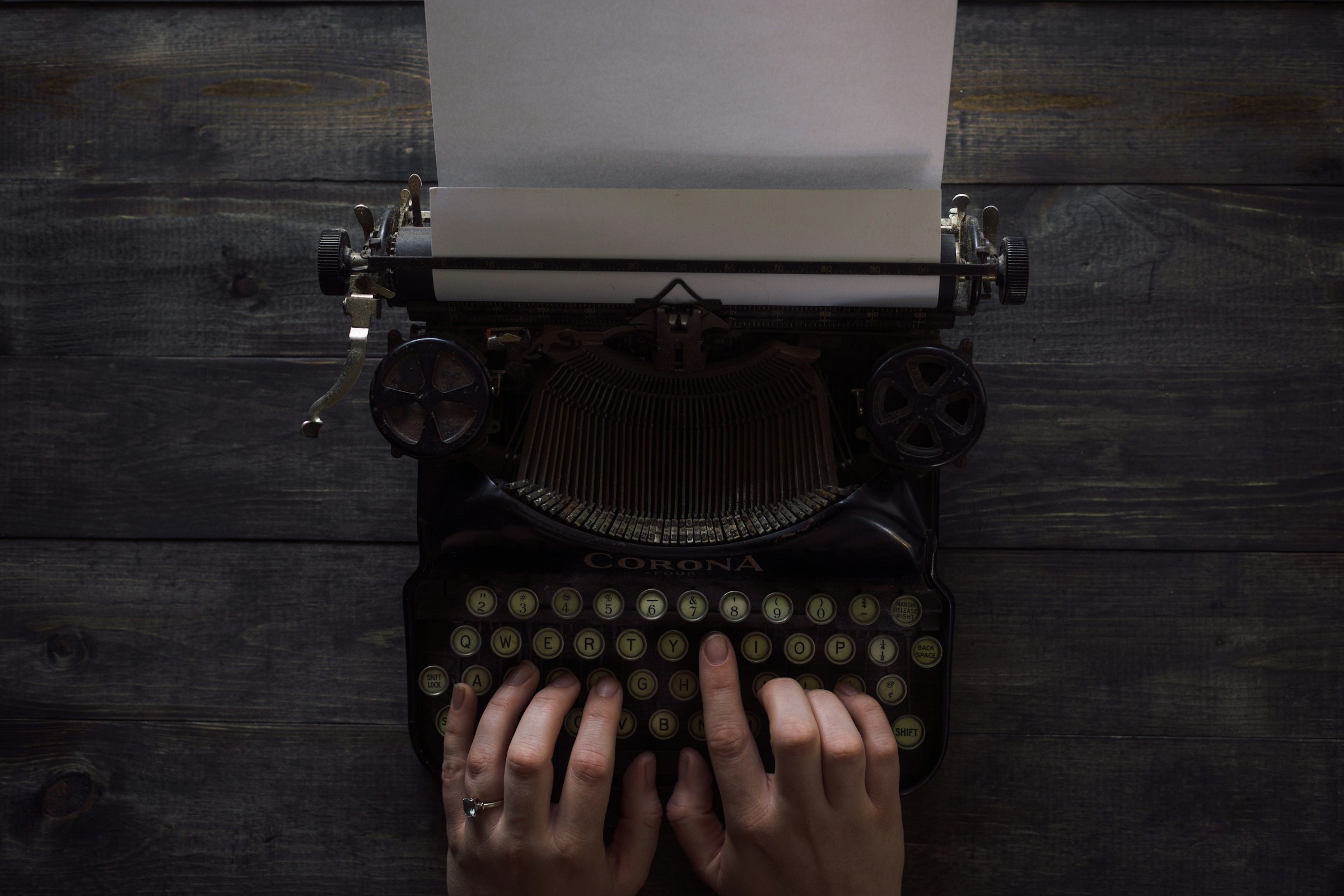 person holding white and black typewriter