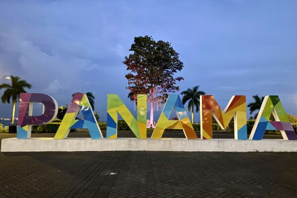a large sign that says panama with a tree in the background