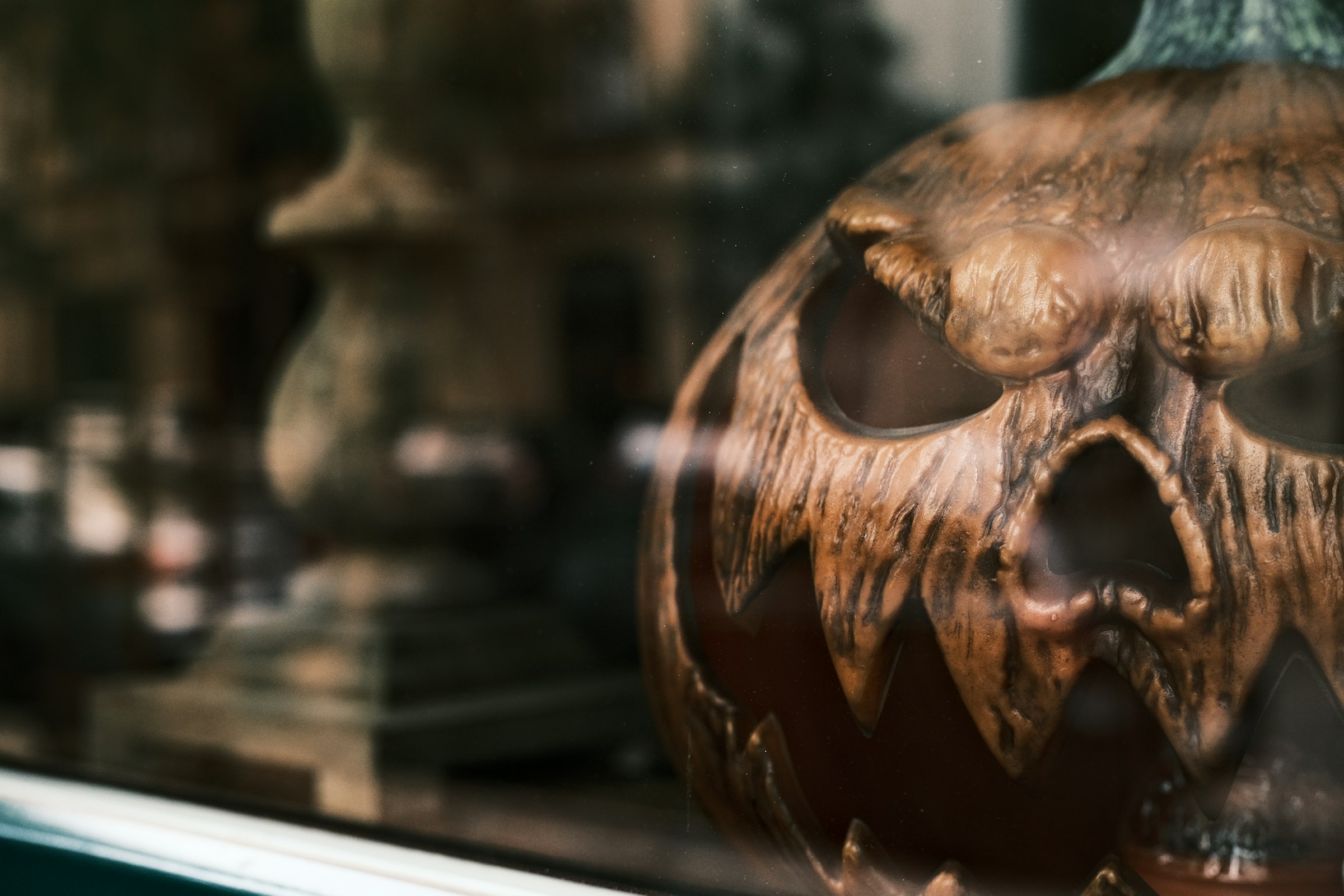 A carved wooden pumpkin with a spooky face.