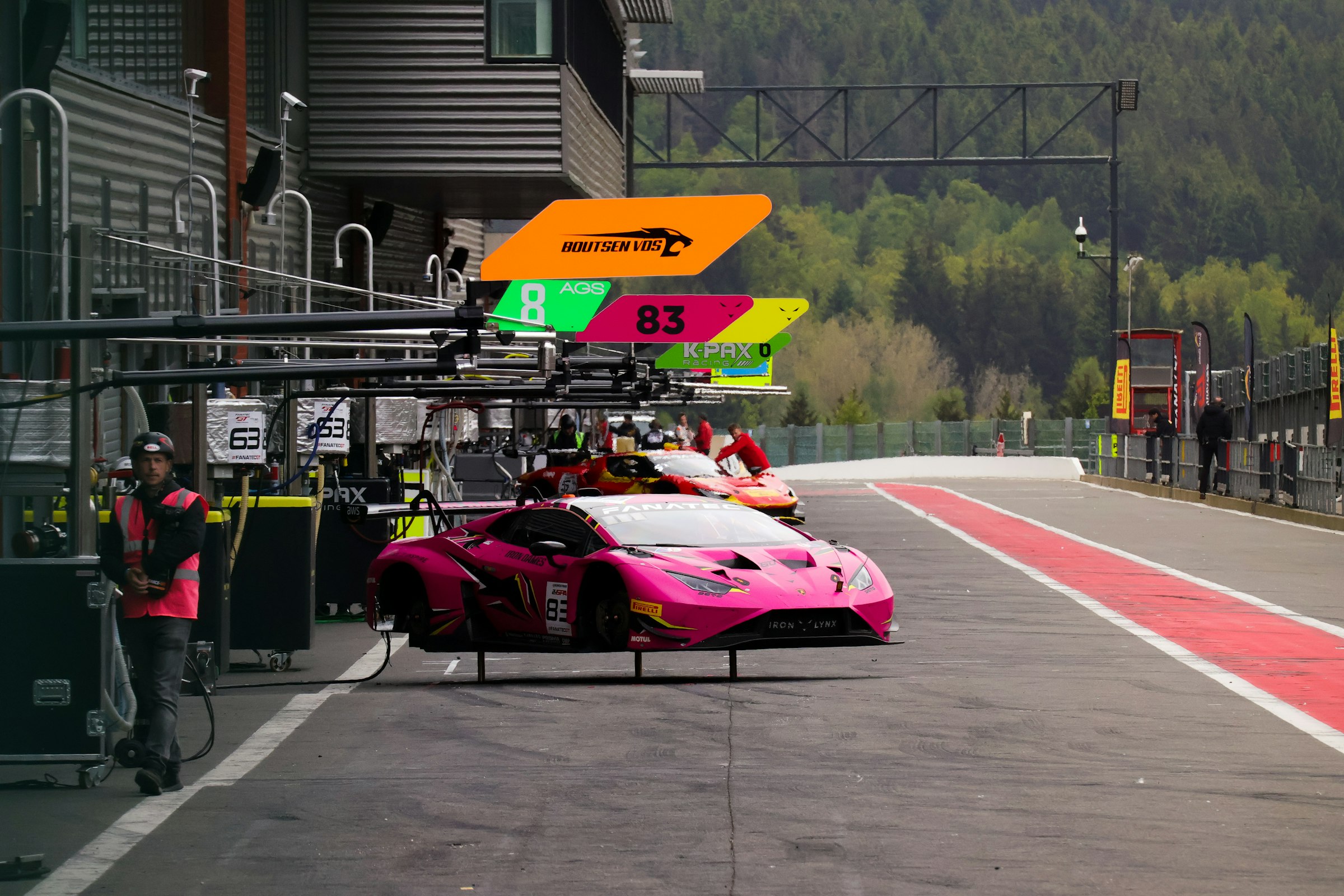 a pink race car driving down a race track