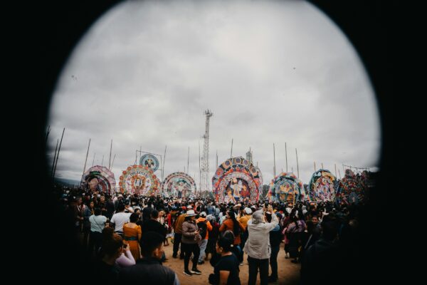 A crowd of people standing around a carnival ride