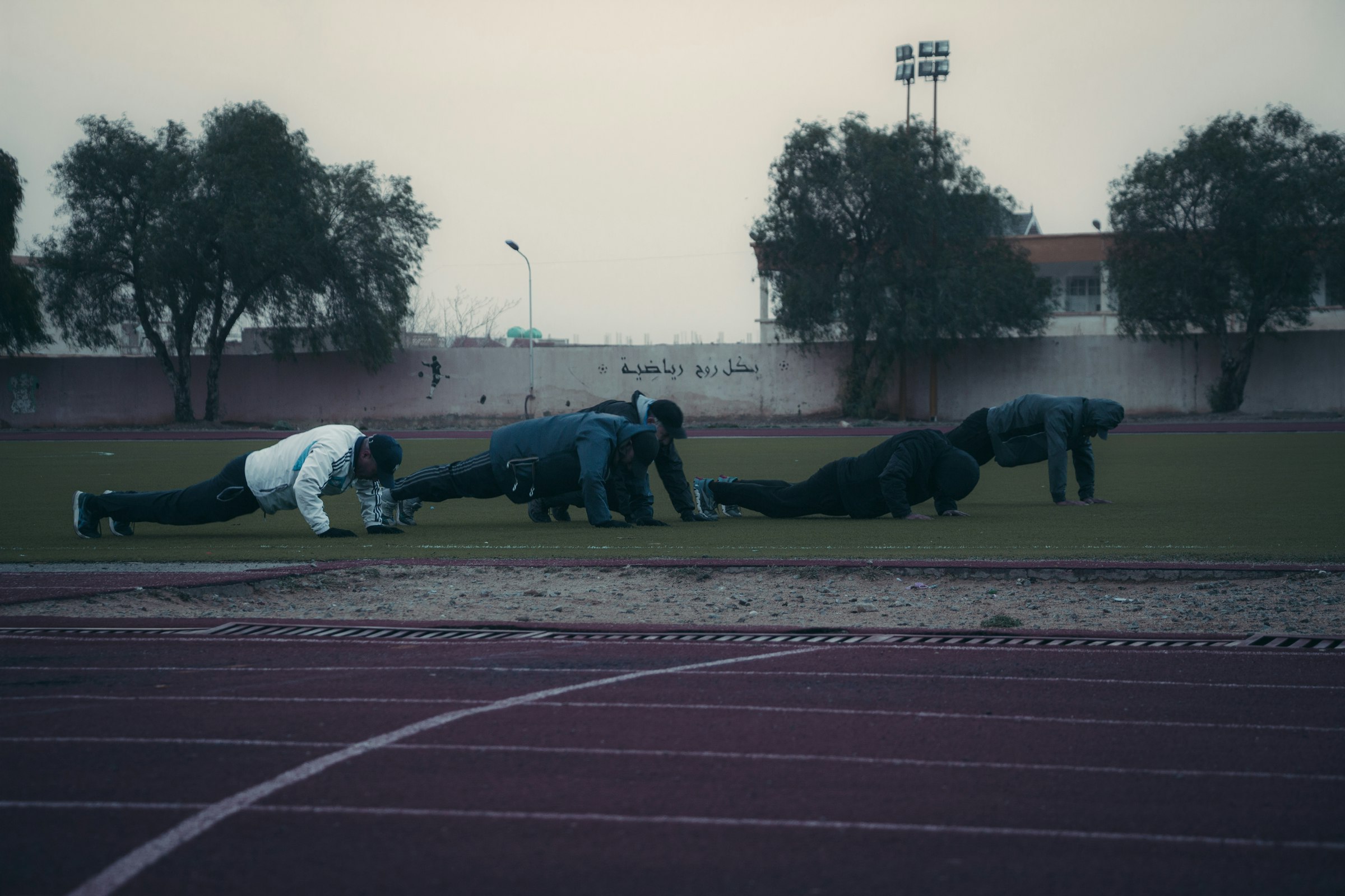 a group of people on a track doing push ups