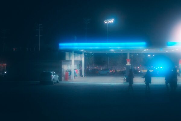a couple of people standing in front of a gas station