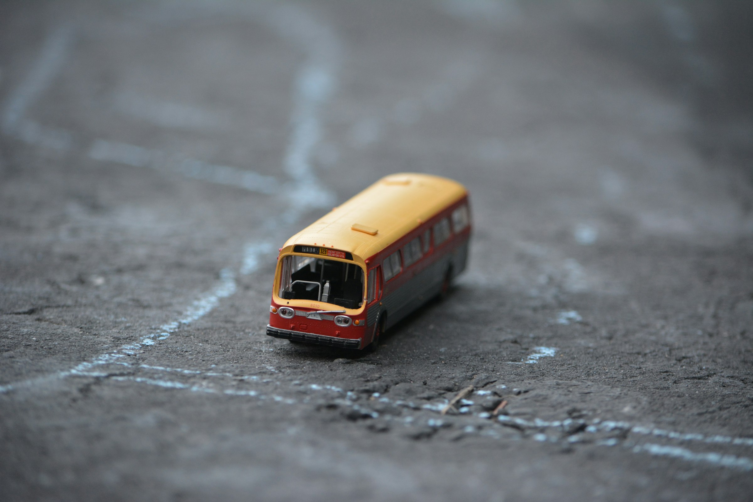 a toy bus is sitting on the ground